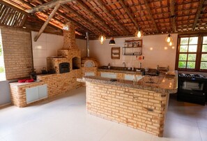A spacious kitchen with a brick island, a built-in oven, and a large window providing natural light.