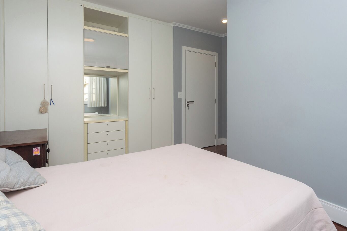 Un dormitorio con cama, cómoda, espejo y puerta.