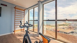 Ein Zimmer mit einem großen Fenster, einem Fahrrad und einer Holzleiter.