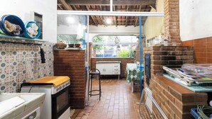 Una cocina compacta con pared de ladrillo, un pequeño comedor y una ventana con vistas a zonas verdes.