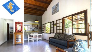 Un grand espace de vie comprenant un canapé, une table à manger et une cuisine à l’arrière-plan.