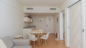A compact living space with a kitchenette, a dining area, and a sofa. - Flat c Academia, Sauna e Garagem - Jardim Paulista (São Paulo)