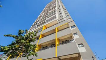 Um edifício alto com várias varandas e um céu azul límpido.