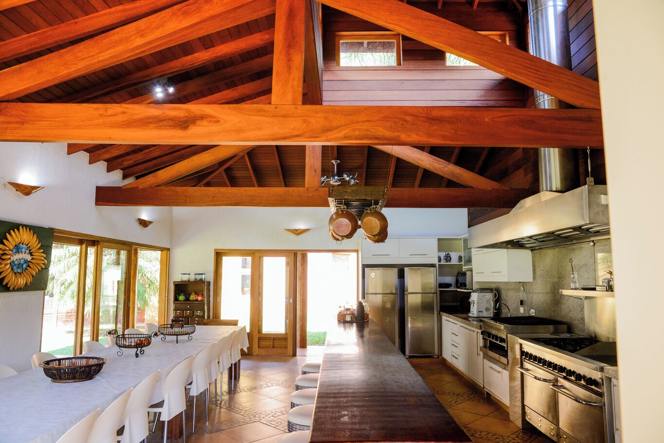 A spacious kitchen with high ceilings, wooden beams, and modern appliances.