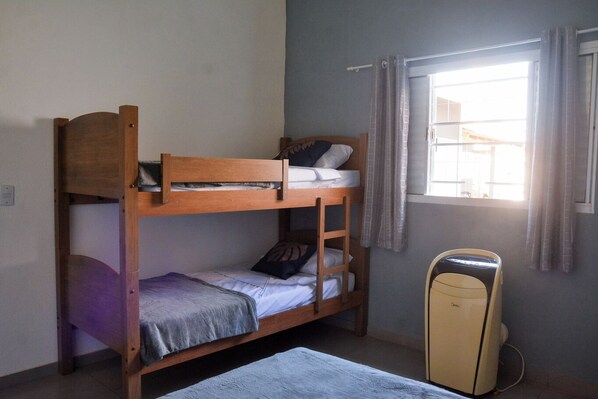 A bunk bed room with a window and a small heater.