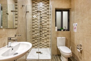A modern bathroom with a glass-enclosed shower, a white sink, and a toilet. - Modern 2BR Urban Retreat in Msida (Msida)