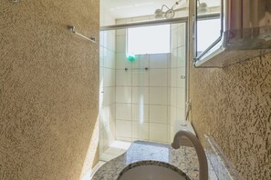 Ein Badezimmer mit Dusche, Waschbecken und Handtuchhalter.