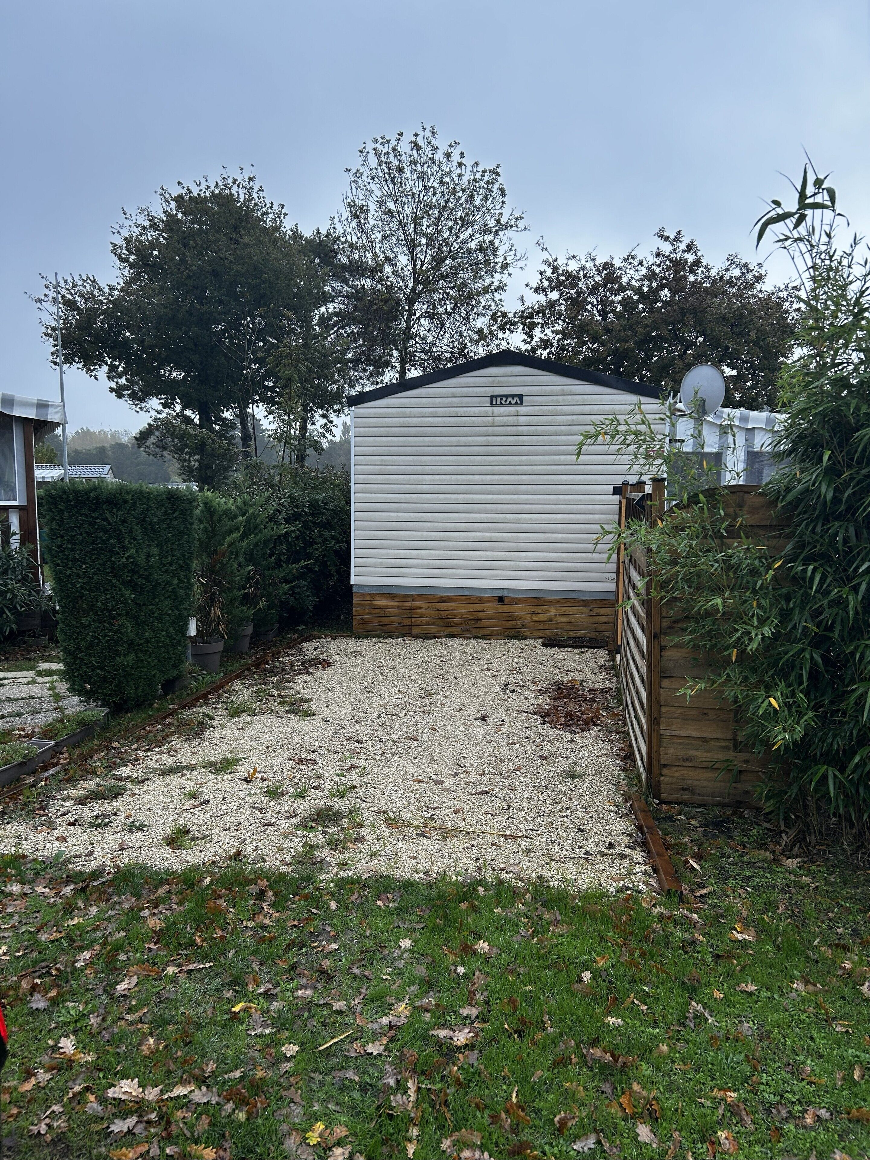 Ein Bungalowmobilheim mit Schotterweg und Holzzaun.