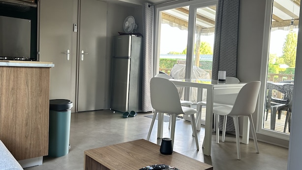 Ein kompakter Wohnbereich mit Küchenzeile, Essbereich und einer Glastür zum Balkon.