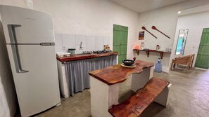 Eine kleine Küche mit einem weißen Kühlschrank, einer Holz Arbeitsplatte und einer grünen Tür.