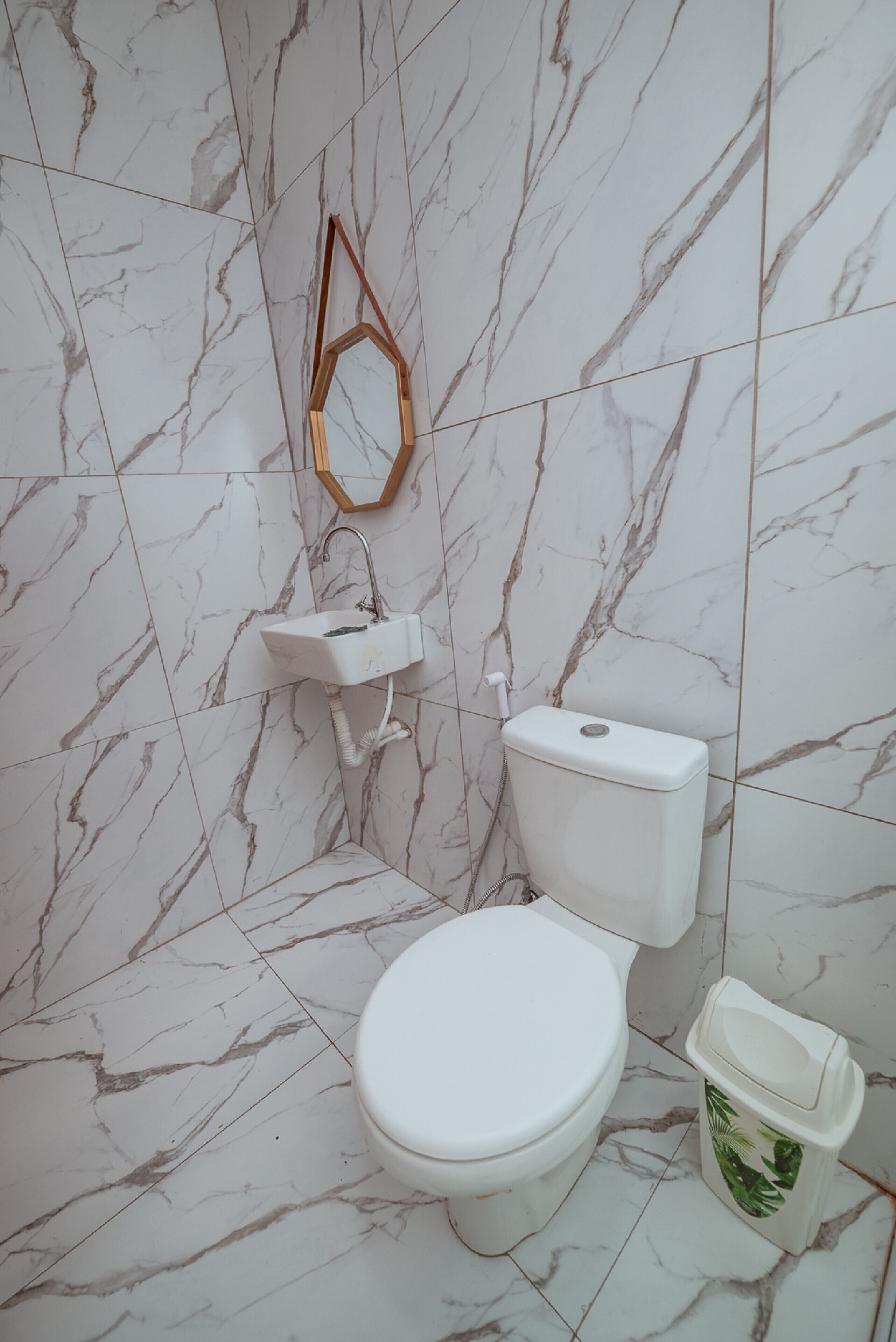 Ein Badezimmer mit Toilette, Waschbecken und Spiegel.