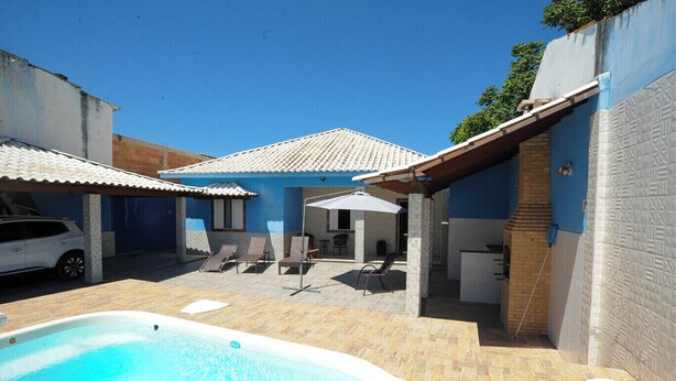 Ein Poolbereich mit Whirlpool, Liegestühlen und einer überdachten Terrasse.