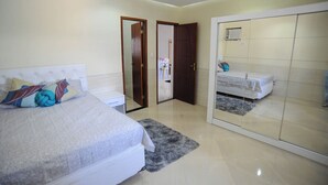 Ein Schlafzimmer mit Bett, Nachttisch, Kleiderschrank und Spiegel.