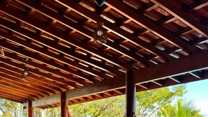 A covered outdoor area with a picnic table, hammocks, and a pool.