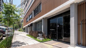 Ein modernes Gebäude mit einer Schaufensterfront mit der Aufschrift "CORAZ STUDIOS" und einem Parkplatz mit mehreren Fahrzeugen.