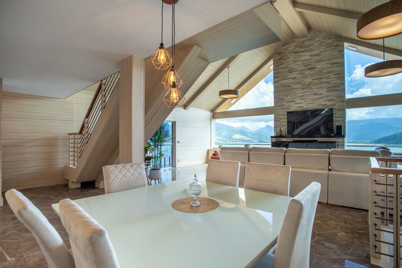 Un interior modern amb zona de dinar, escala i cuina amb vistes.