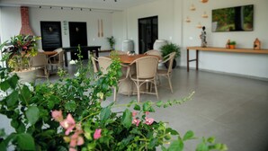 Un vaste espace de vie comprenant une table et des chaises, une cheminée et diverses plantes.