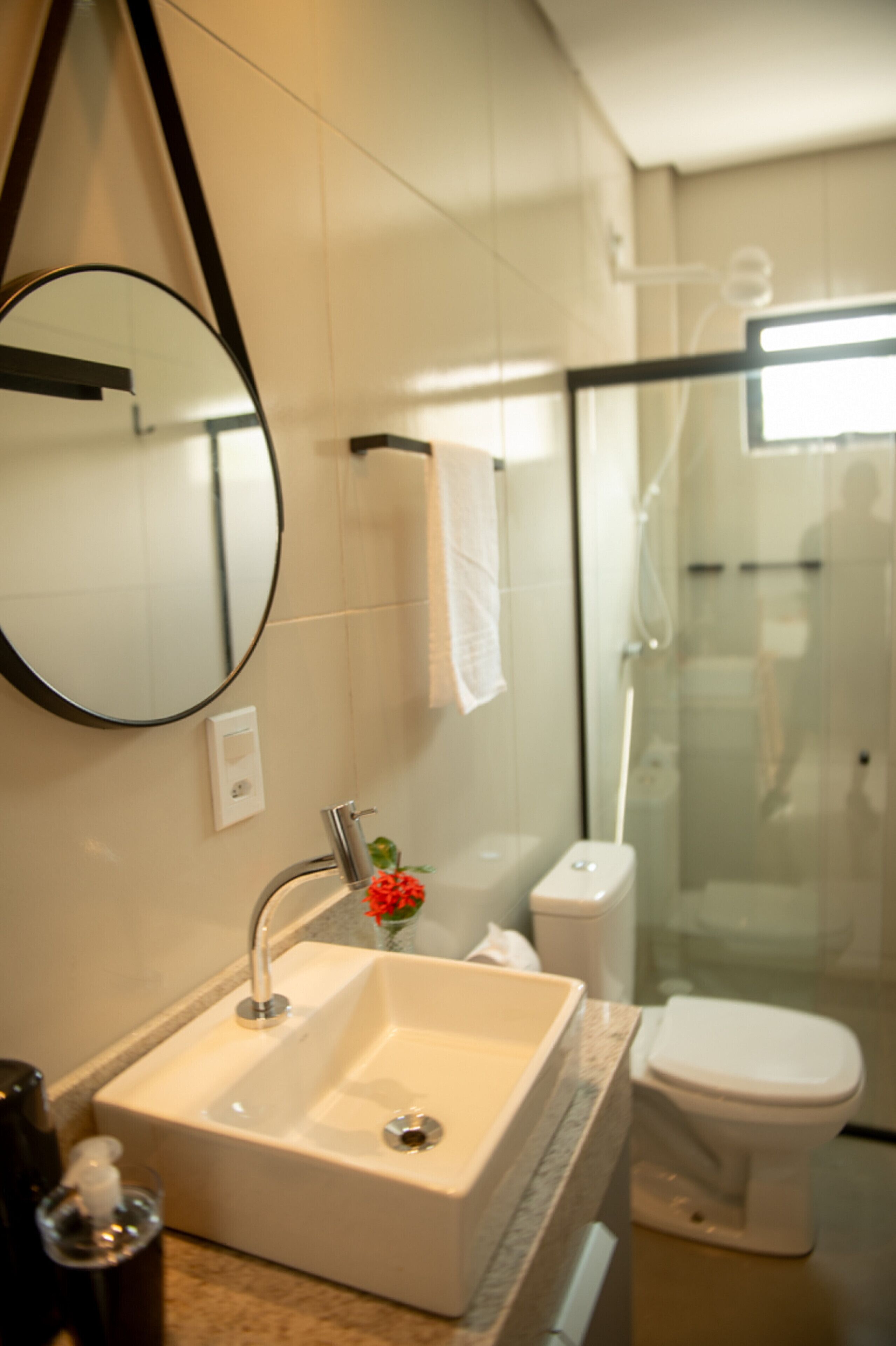 Ein Badezimmer mit weißem Waschbecken, Spiegel und Toilette.