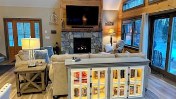 TV connectée, cheminée, livres, écrans d'ordinateur