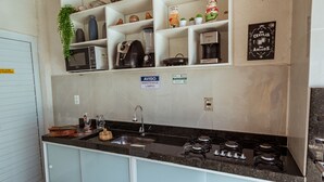 Una cocina con estufa integrada, pileta y alacenas superiores.