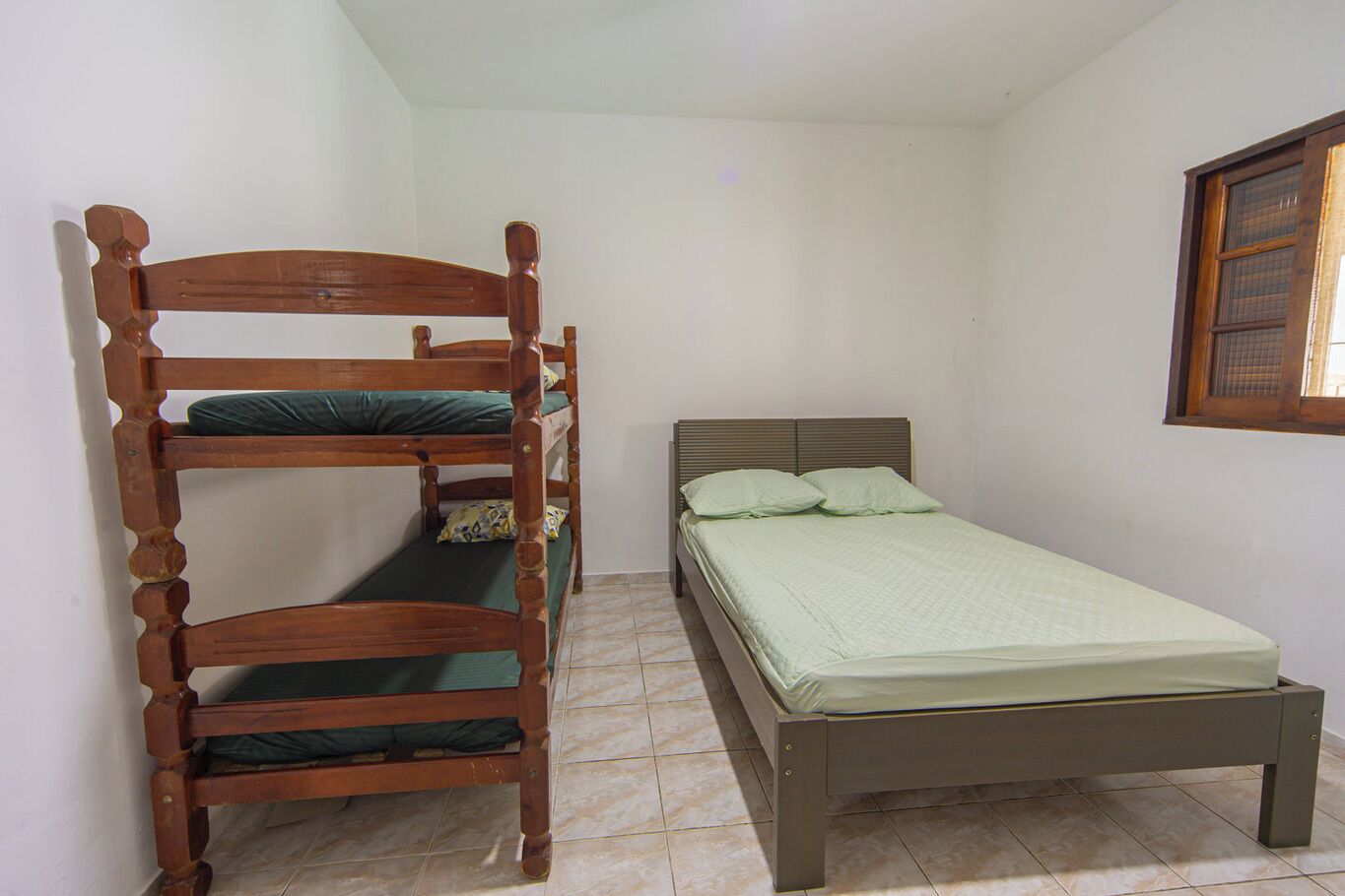 A room with a bunk bed and a single bed.