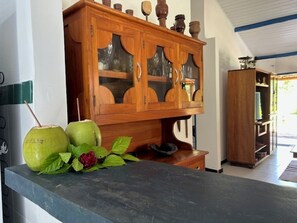 Ein Holzkabinett mit Glastüren, einer Steinarbeitsplatte und einer roten Blume.