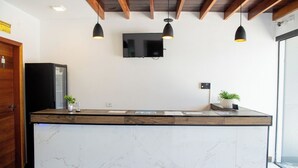 Een moderne keuken met een marmeren aanrecht, houten balken en hanglampen.