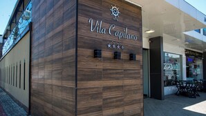 Een gebouw met een houten gevel en de naam 'Vila Capilano' duidelijk zichtbaar.