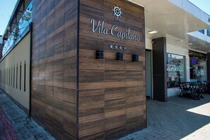 Ein Gebäude mit einer Holzfassade, auf der der Name "Vila Capilano" gut sichtbar angebracht ist.