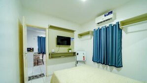 A hotel room with a bed, a TV mounted on the wall, a water dispenser, and a shower curtain. - Flat com Wi-Fi a Poucos Metros do Aeroporto (Fortaleza)