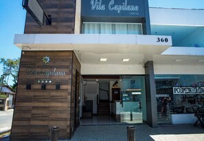 Das Äußere der Vila Capilano Lofts, mit modernem Design, einem markanten Eingang und einem sichtbaren Schaufenster.