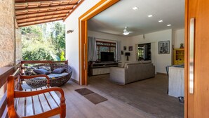 Amplia sala de estar con un banco de madera, un sofá de mimbre y un sofá beige.