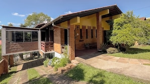 Ein zweistöckiges Haus mit Balkon, Terrasse und Garten.