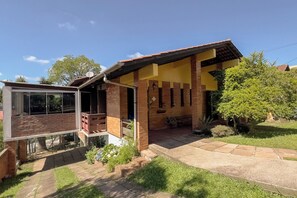 A two-story house with a balcony, a covered porch, and a stone pathway leading to the entrance. - Casa com Vista, Lareira e Churrasqueira na Serra (Bento Gonçalves)