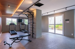 A spacious room with a pull-up bar, two treadmills, and a bench.