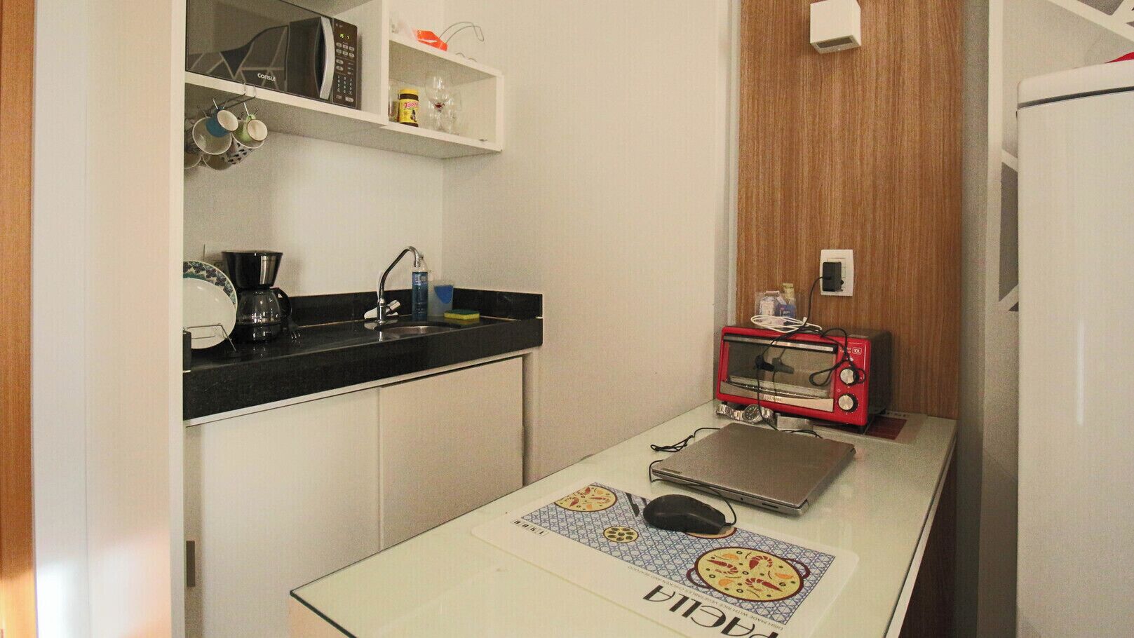 Une petite cuisine équipée d’un four à micro-ondes, d’un grille-pain et d’une machine à café.