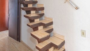 A spiral staircase with wooden steps leading to a landing. - Casa para 9 com Piscina e Churrasqueira | São Carl (São Carlos)