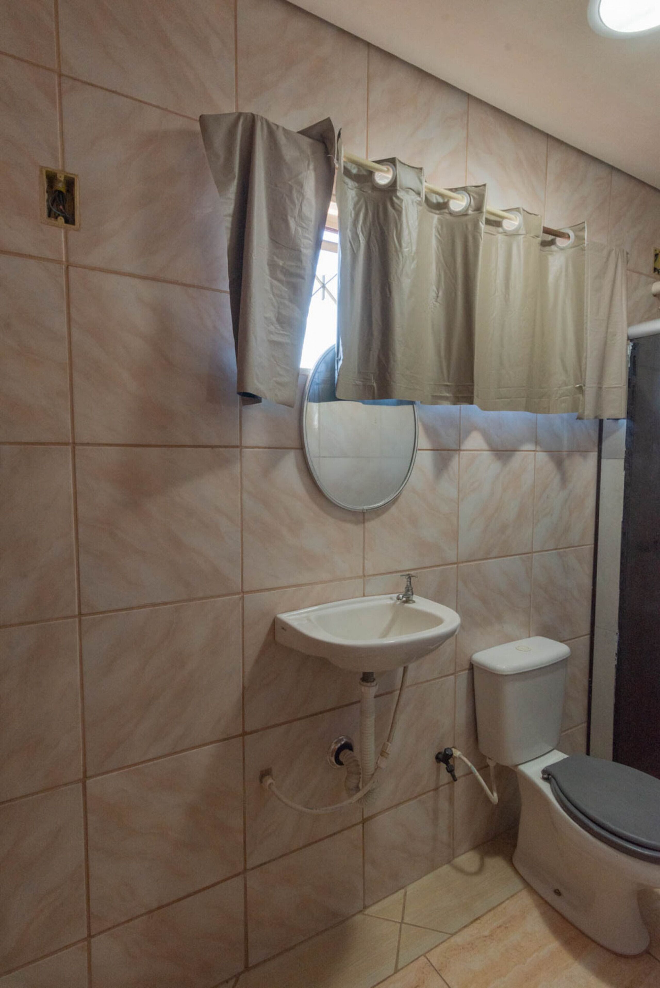 A bathroom with a sink, toilet, and a mirror.