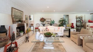 A living room with a fireplace, a sofa, a coffee table, and a bookshelf. - Casa com Piscina, Churrasqueira, Jogos e Lareira (Petropolis)