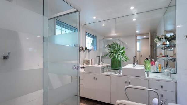 A modern bathroom with a glass shower enclosure, a large mirror, and a potted plant. - Casa com Piscina, Churrasqueira, Jogos e Lareira (Petropolis)