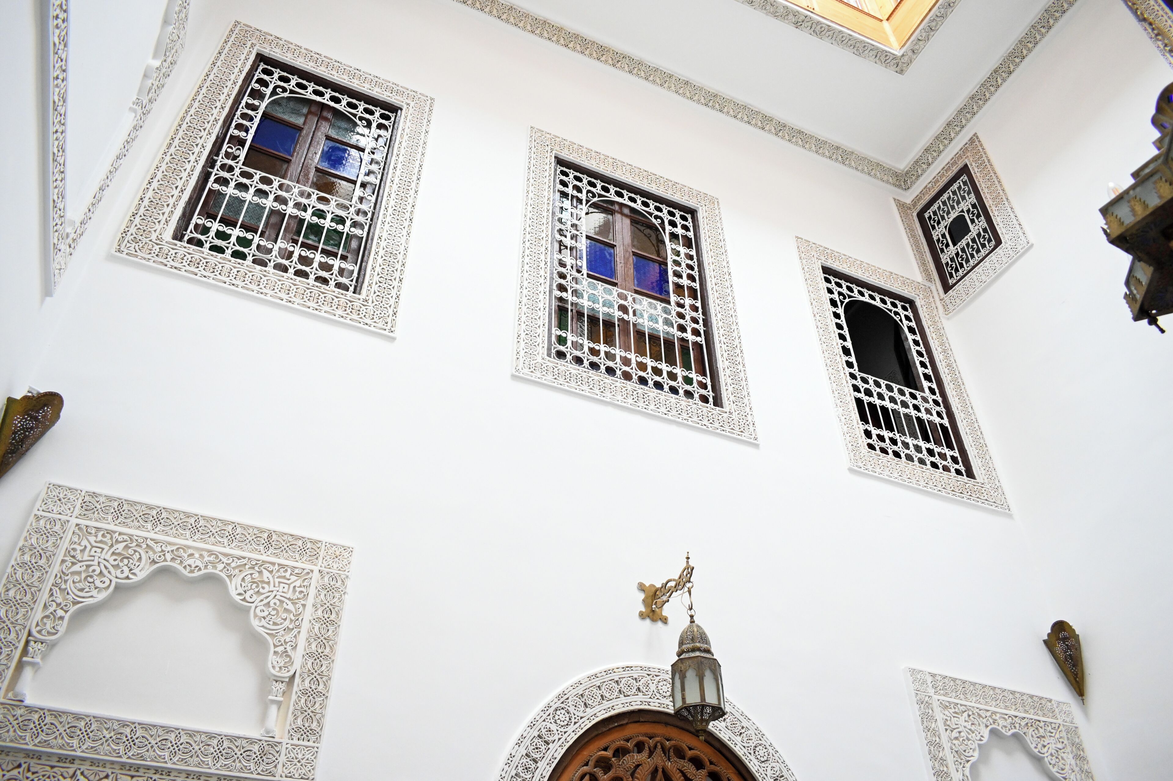 A building with ornate white architectural details, including intricate window designs and decorative elements.