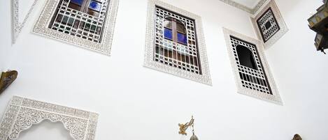 A building with ornate white architectural details, including intricate window designs and decorative elements.
