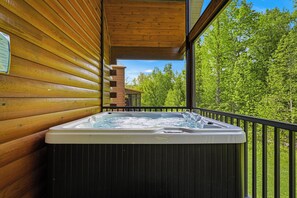 A hot tub on a balcony with wooden walls and a view of trees. - Gatlinburg*Small but Spacious*WiFi*Hot Tub*Resort Amenities (Gatlinburg)