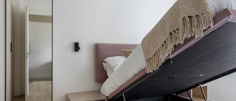 Ein Schlafzimmer mit einem Bett, einem Nachttisch, einem Spiegel und einem Kleiderschrank.