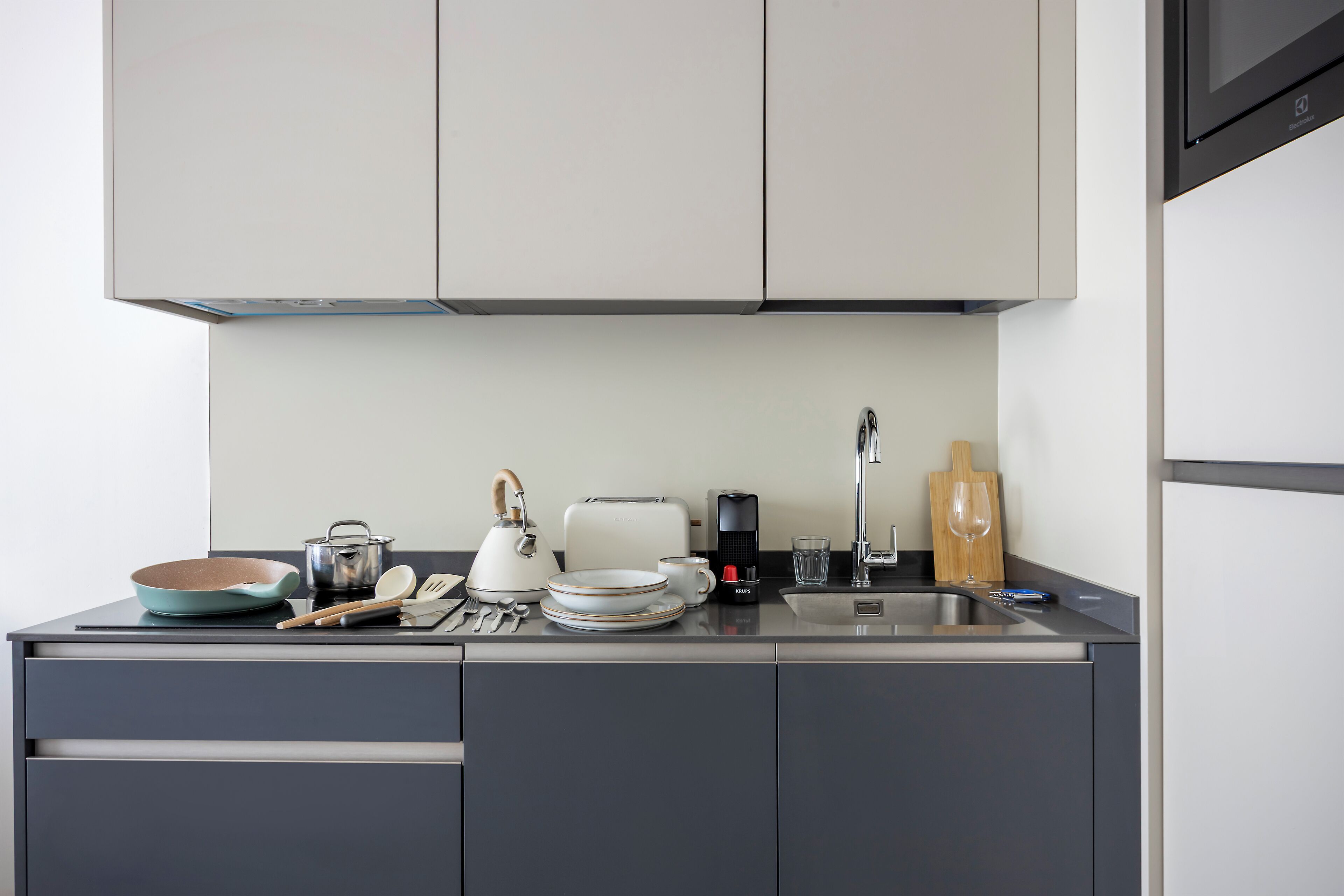 Una cocina moderna con encimera de acero inoxidable, tostadora, hervidor y cafetera.