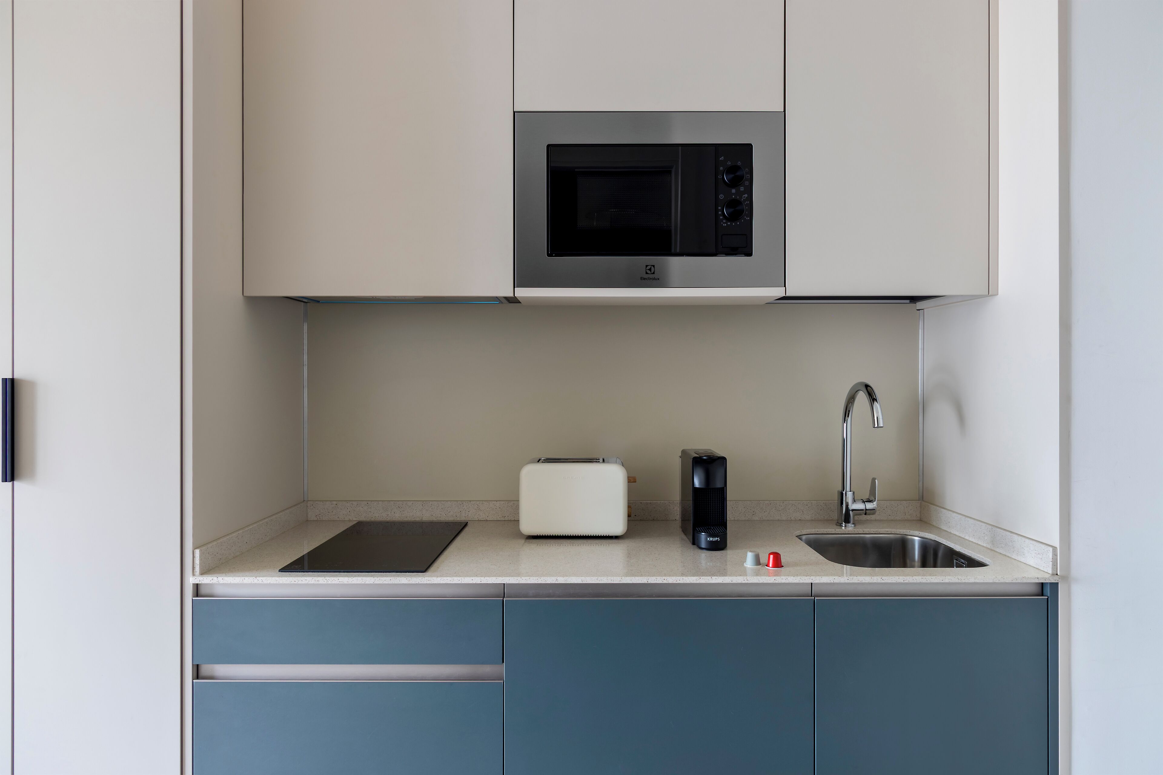 Una cocina moderna con microondas, tostadora y pileta.