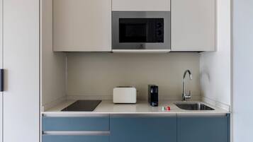Una cocina moderna con microondas, tostadora y pileta.