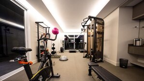 A home gym with exercise equipment, a bench, and a treadmill. - Fazenda Bom Retiro Hotel Boutique (Bom Retiro)