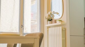 A room with a window, a radiator, a mirror, and a shelf with flowers. - Casa Sophie - One Bedroom Apartment, Sleeps 4 (Desenzano del Garda)