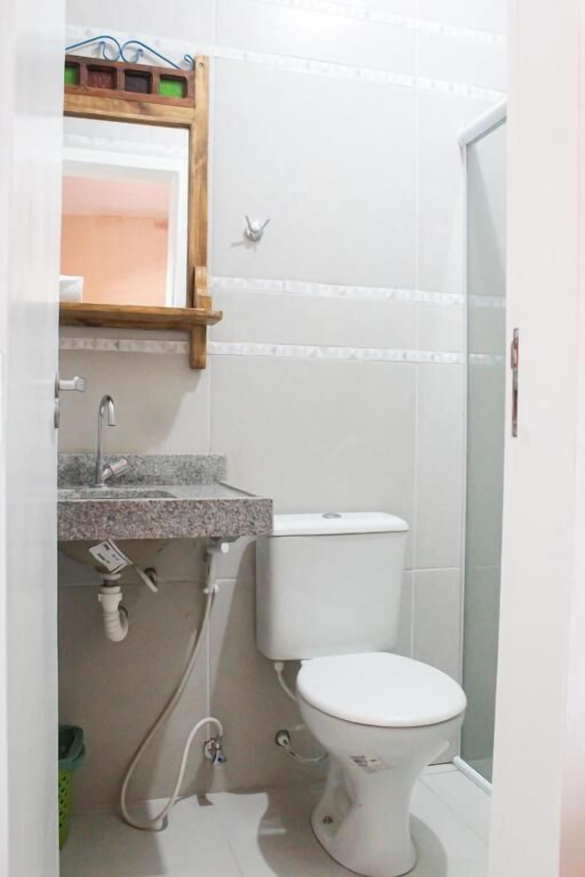 Un baño con lavamanos, inodoro y zona de ducha.